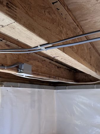 A room featuring a ceiling and a wall adorned with various wires.