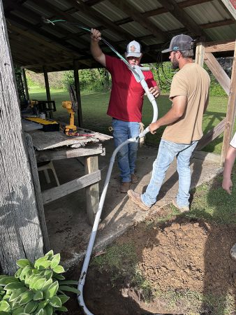 A group of men collaborating on a project, discussing ideas and reviewing materials together.