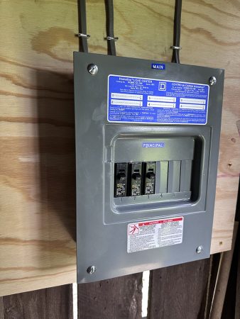 A panel with three wires connected to it, showcasing electrical components and connections.