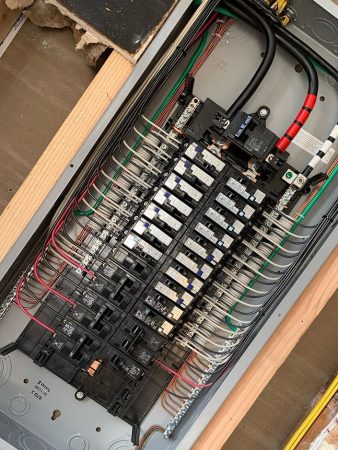 A panel box containing various wires and electrical equipment, showcasing its internal components and organization.