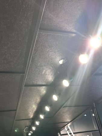 A ceiling with lights illuminating a table positioned in the center of the room.