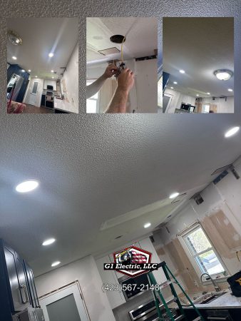 A man installs a ceiling light in a modern kitchen, using tools and focused on the task at hand.